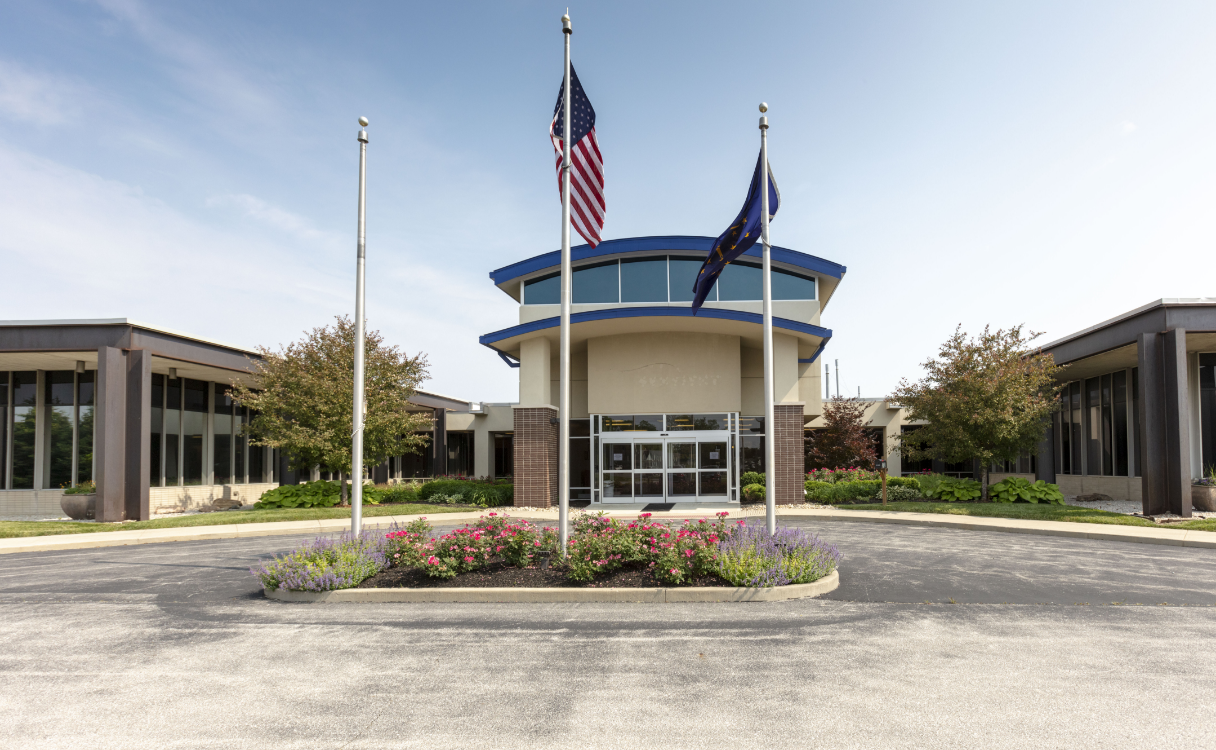 A building with flags and flowers in front of it