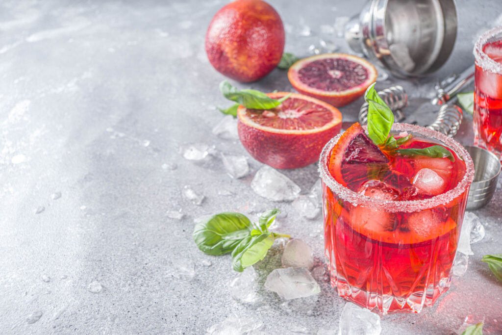 a couple of glasses filled with red liquid