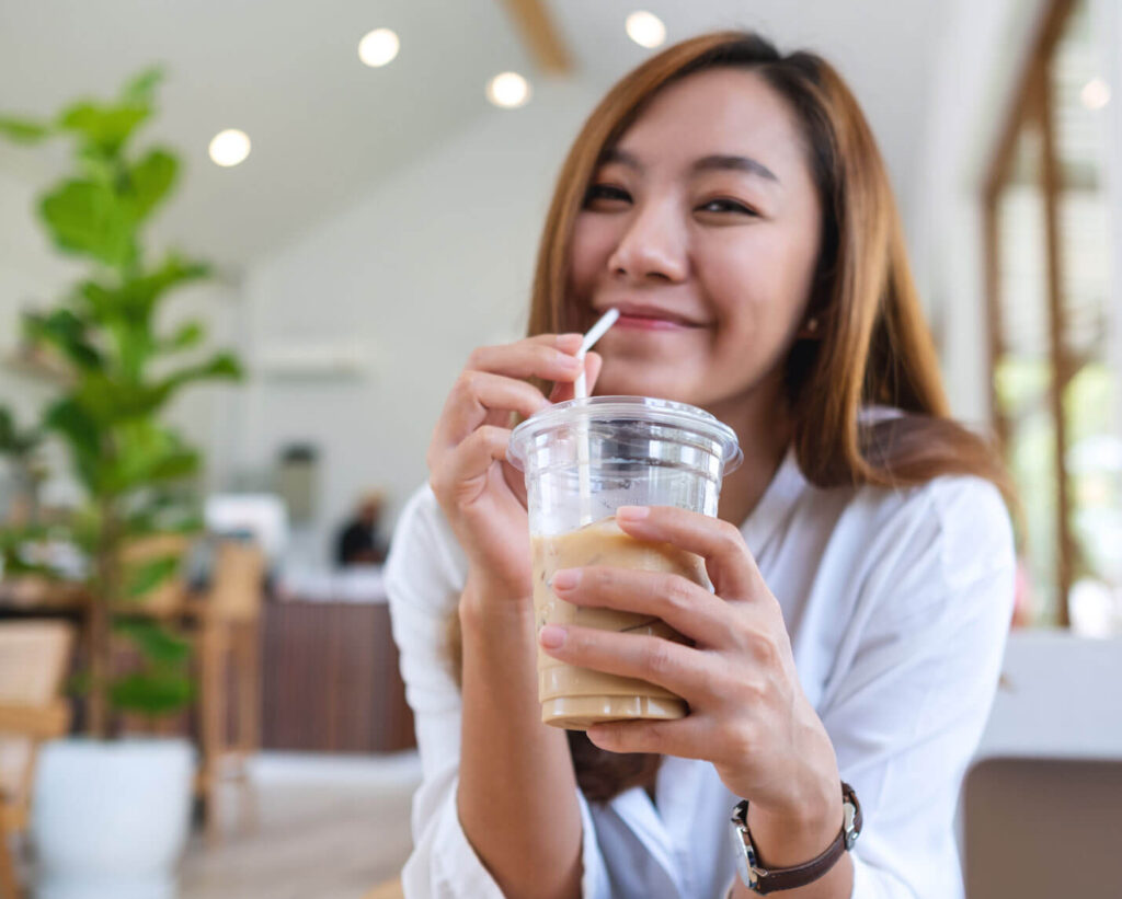 A woman enjoying a beverage while seated at a table